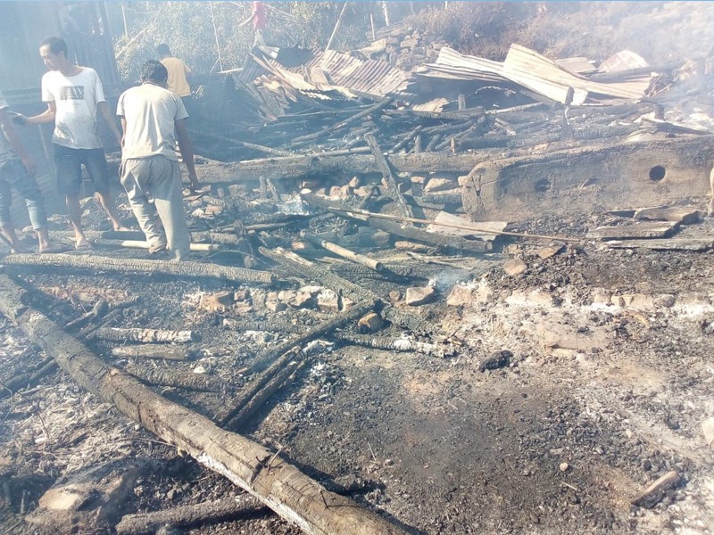 Villagers look on at the remnants of a house that was razed in a fire in Wakching village on November 8. (Morung Photo)